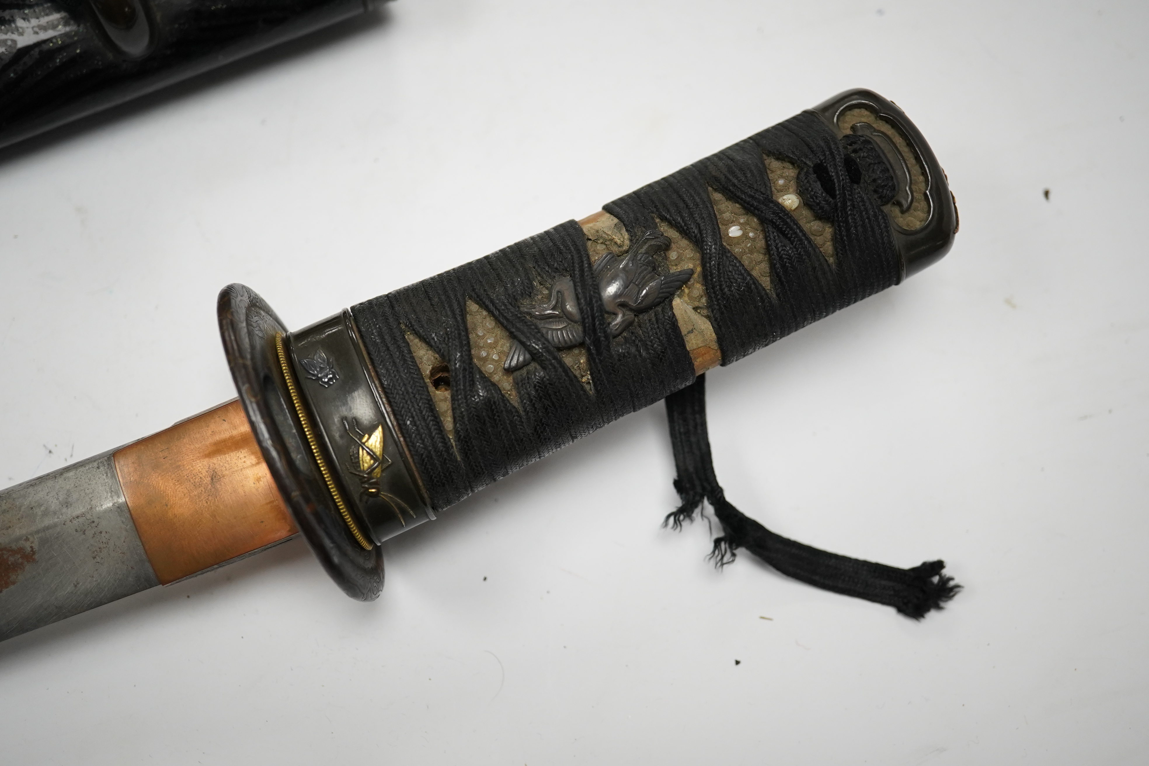 A Japanese tanto dagger, blade 26.8cm, unsigned, suriage, copper tsuba, tape bound tsuka, shakudo fuchi kashira with gilt insects, in its black lacquered saya with matching mounts and iron kodzuka. Condition - fair, some